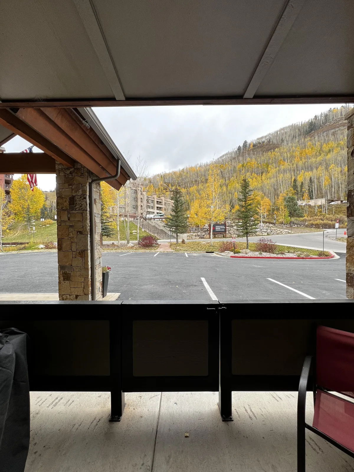 An outdoor scene with a private seating area on a balcony or patio, offering tranquil views of the mountains and vibrant autumn foliage. The space is designed for relaxation and soaking in the fresh mountain air.